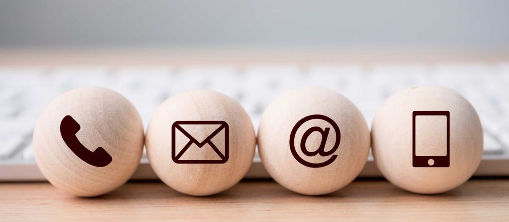 4 Holzkugeln mit Kommunikationsoptionen: Telefon, Brief, E-mail und Handy.